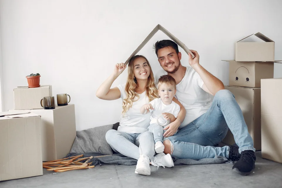 Família entre caixas de mudança planejando a vida em uma nova casa